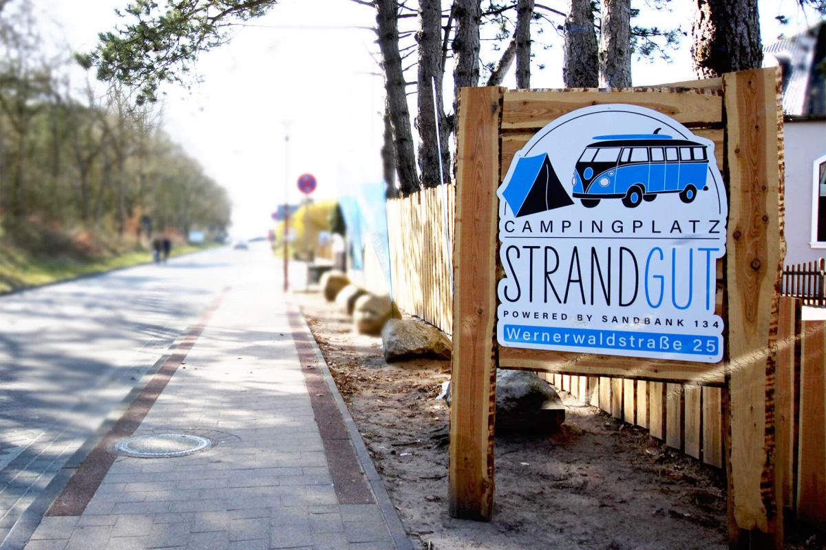 Straße mit Schild Strandgut Campingplatz Logo